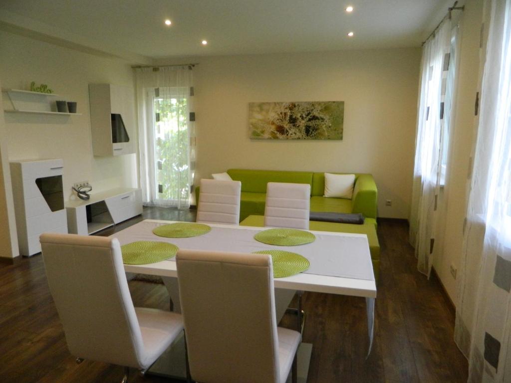 sala de estar con mesa y sofá verde en Greentó Apartman en Balatonföldvár