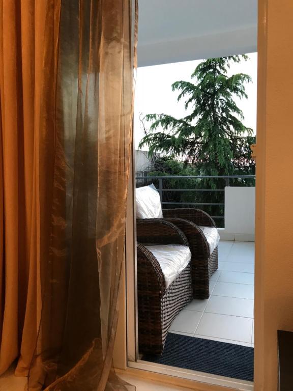 przesuwane szklane drzwi z wiklinowym krzesłem na balkonie w obiekcie Villa Diana w mieście Utjeha
