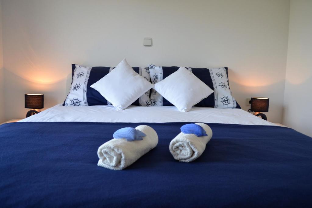 a bedroom with a blue bed with towels on it at Apartments Marko in Poreč