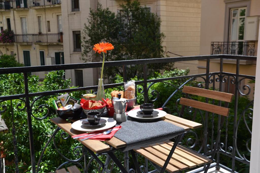 a table on a balcony with food and drinks at Casa Arcoiris in Naples