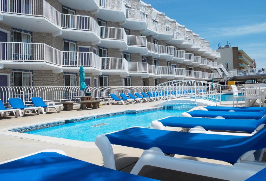 a swimming pool with blue chairs and a hotel at Shalimar Resort in Wildwood Crest