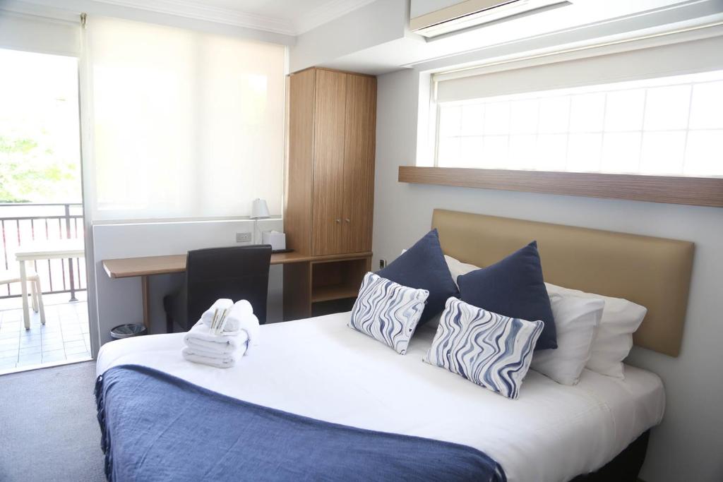 a bedroom with a bed with blue and white pillows at The Blenheim in Sydney