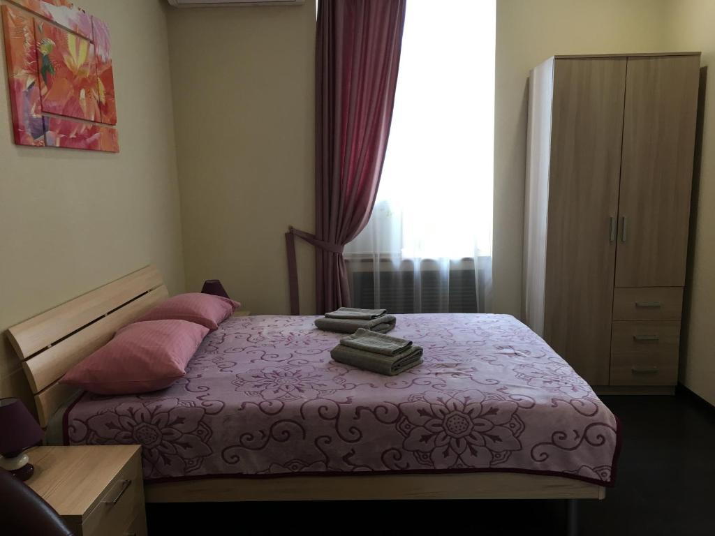 um quarto com uma cama com lençóis cor-de-rosa e almofadas cor-de-rosa em VladStar INN em Vladivostok