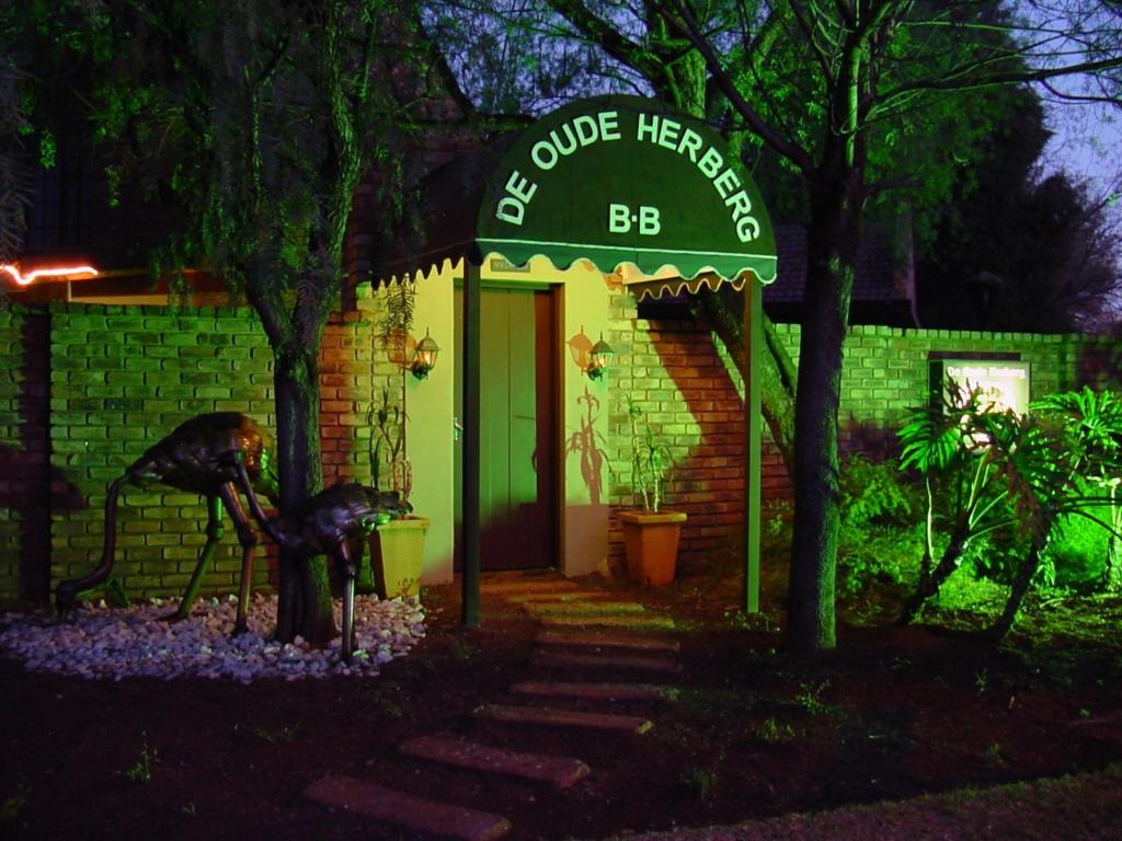 ein grünes Gebäude mit einem Schild mit der Aufschrift cureheiros bc in der Unterkunft De Oude Herberg in Centurion
