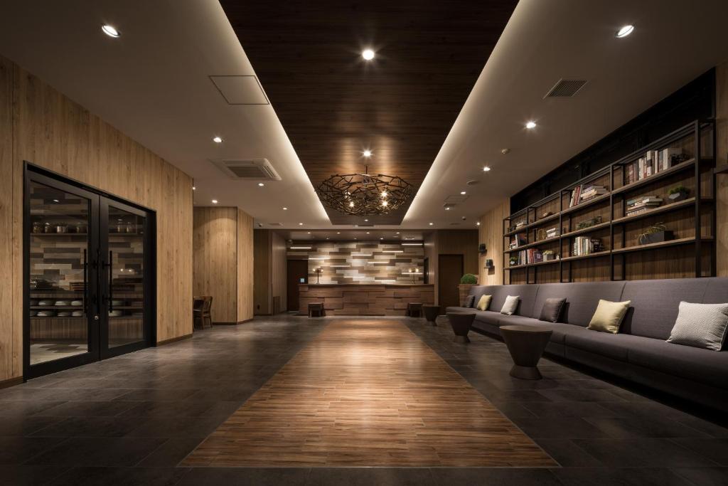 a lobby with couches and a chandelier at Nest Hotel Hakata Station in Fukuoka