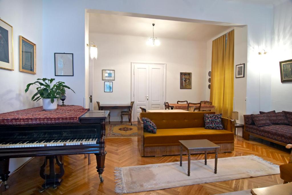 uma sala de estar com um sofá e um piano em Hostel Residence em Saraievo