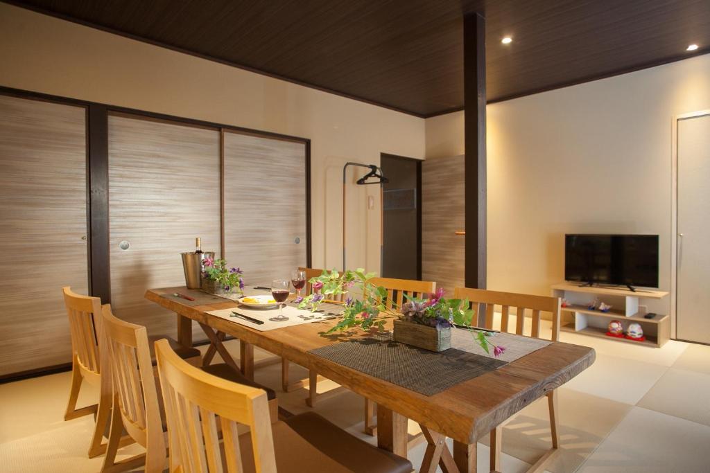 a dining room with a wooden table and chairs at Oyama TABI-NE in Kanazawa