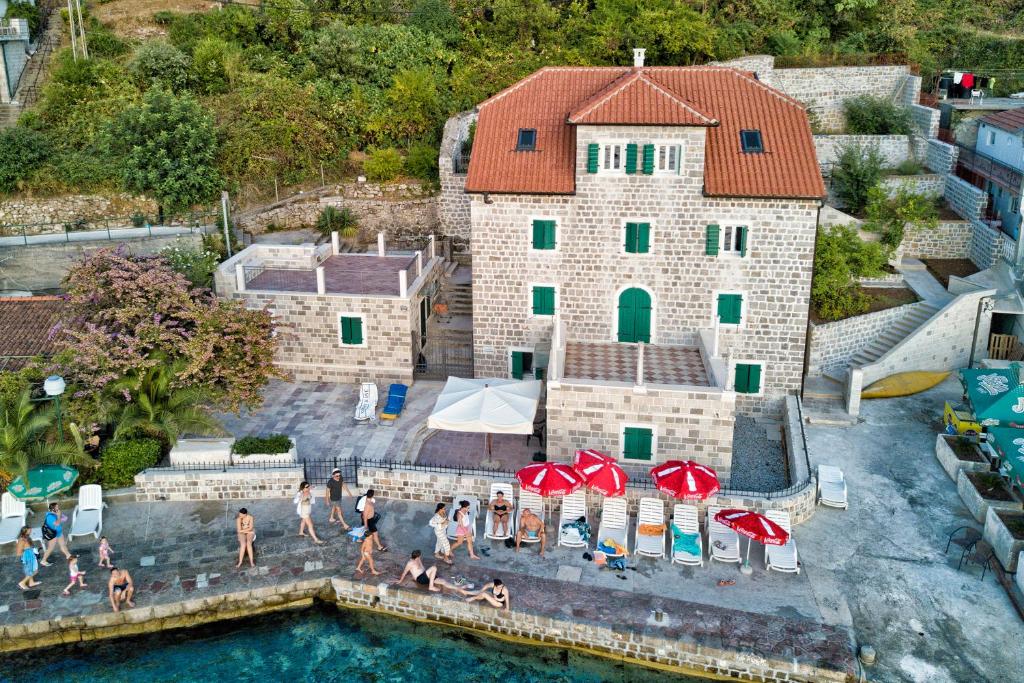 een groep mensen in een zwembad met een gebouw bij Apartments Barizon in Lustica