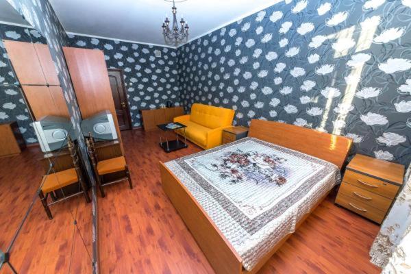 a bedroom with a bed and a chair in a room at Hotel Voikovsky in Moscow