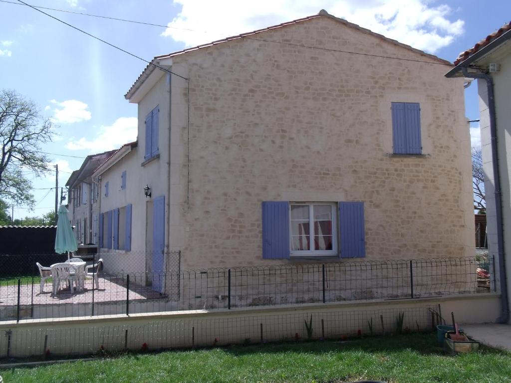 a house with blue shutters and a table in front of it at 17 rue des blanchards in Clam