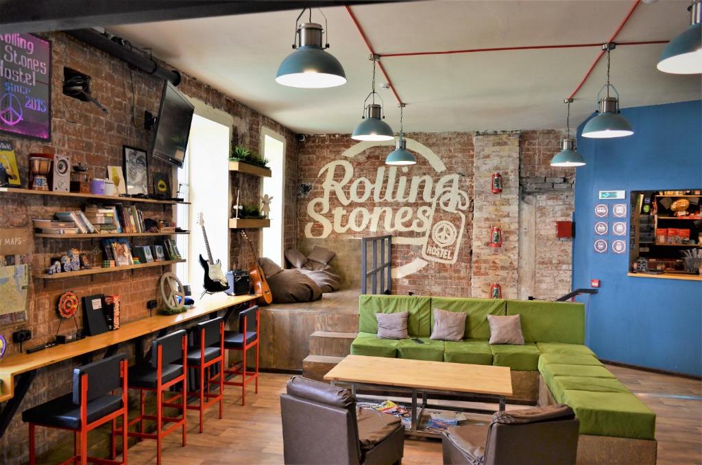 a living room with a green couch and a bar at Rolling Stones hostel in Irkutsk