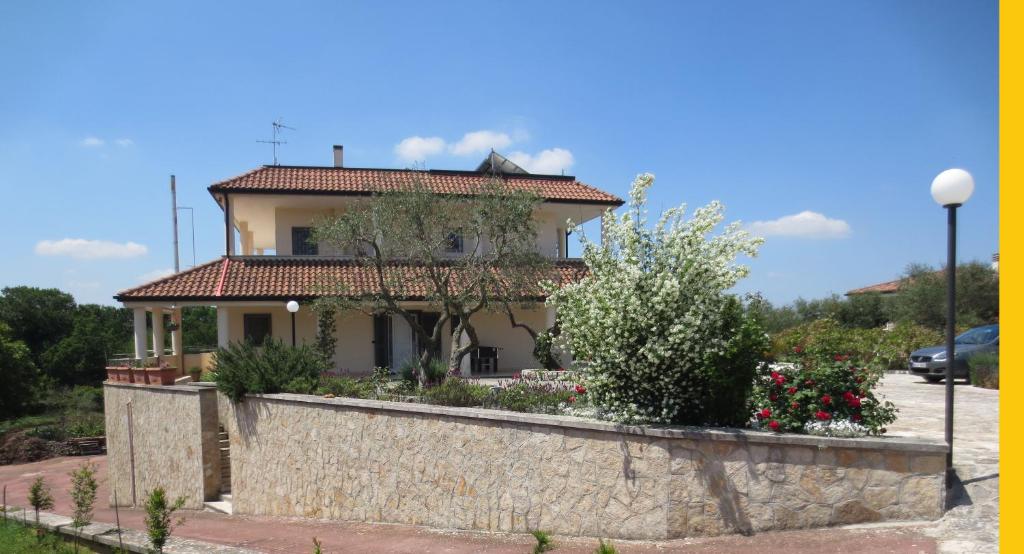 uma casa com uma parede de pedra em frente em Villa Murgese em Noci