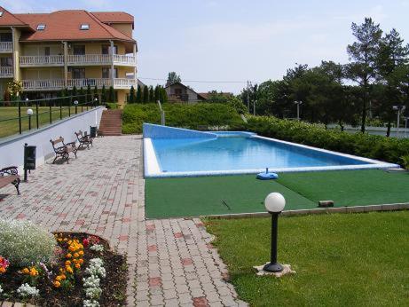une grande piscine en face d'un bâtiment dans l'établissement DElfin Apartmanház, à Balatonfüred