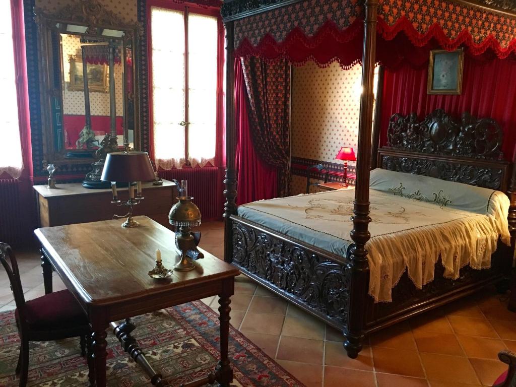 モントーバンにあるDomaine du Fagetのベッドルーム(天蓋付きベッド1台、木製テーブル付)