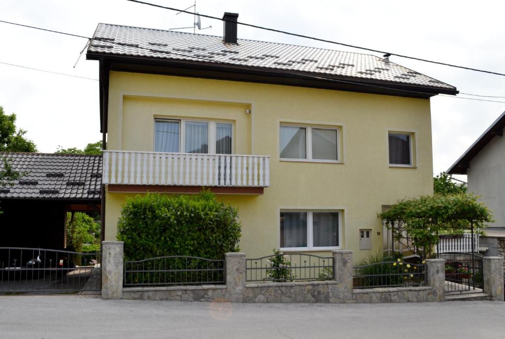 ein gelbes Haus mit einem Zaun davor in der Unterkunft Hill in Slunj