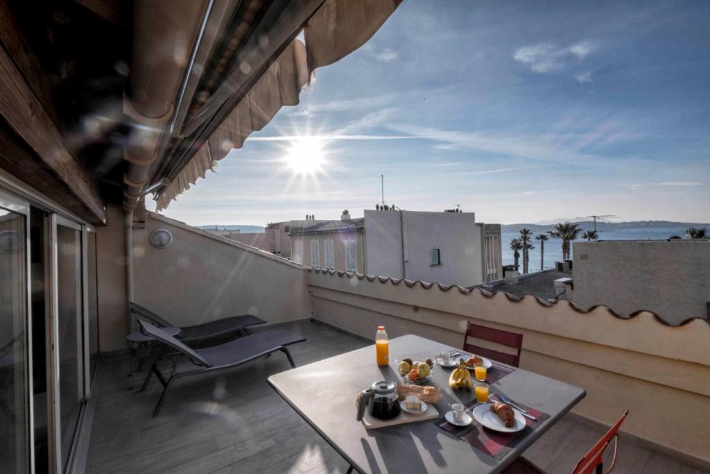 d'un balcon sur le toit avec une table et des chaises. dans l'établissement Coup de coeur: duplex centre ville vue mer & port, à Bandol