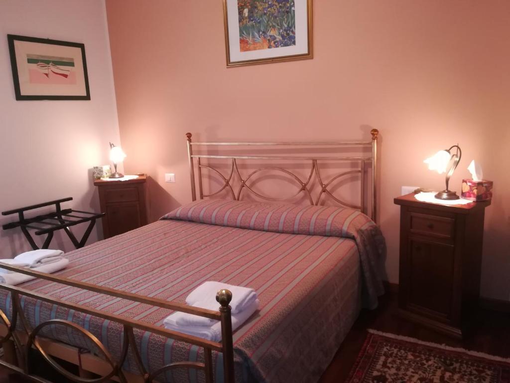 a bedroom with a bed and two night stands with lamps at Domomea in Quartu SantʼElena