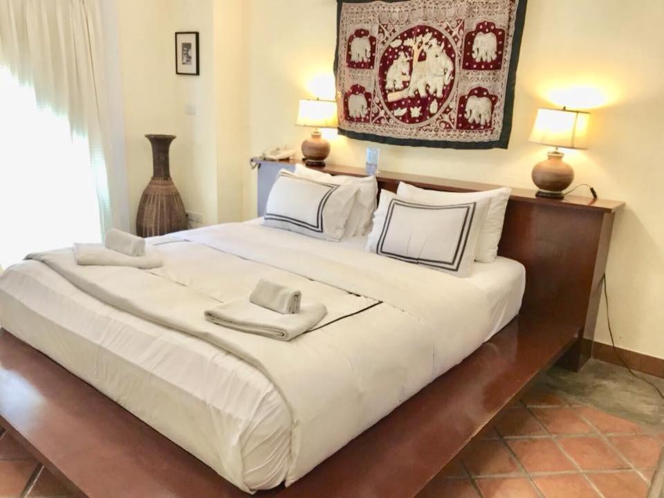 a large white bed with two pillows on it at Nirvana Boutique Suites in Jomtien Beach