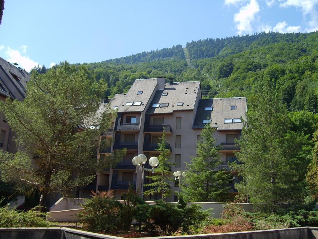 a building with a mountain in the background at Résidence Terrasses d'Etigny in Luchon