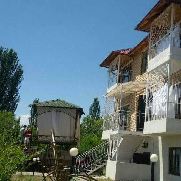 a building with a gazebo on the side of it at Bely Parus in Bosteri