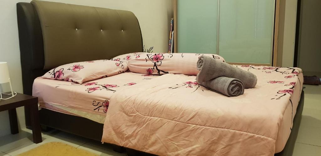 ein Bett mit rosa Bettwäsche und Blumen darauf in der Unterkunft Fahaz Kamunting Taiping in Taiping