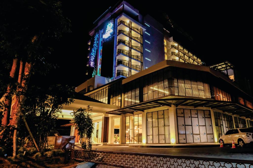 a building with a car parked in front of it at ILLIRA Hotel Banyuwangi in Banyuwangi