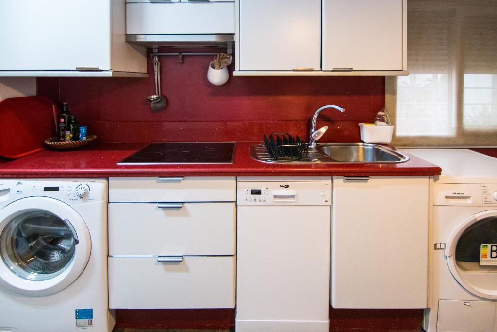 a kitchen with a sink and a washing machine at Utopia Home Alameda in Seville