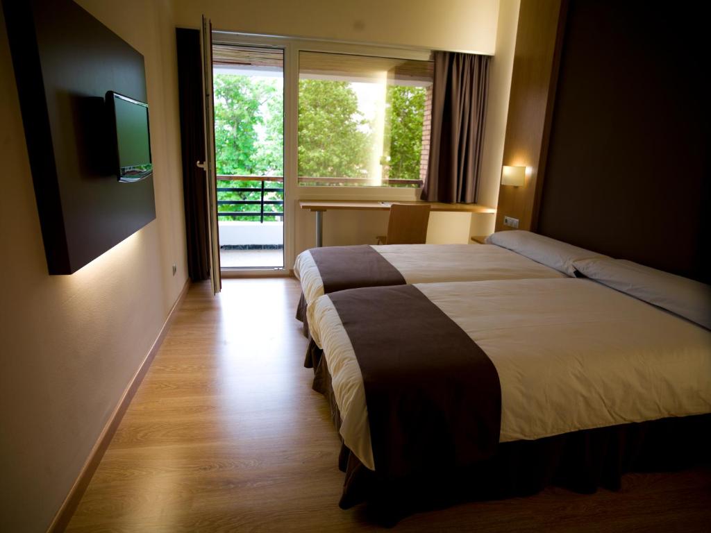 a hotel room with a bed and a television at Hotel Jatorrena in Labastida