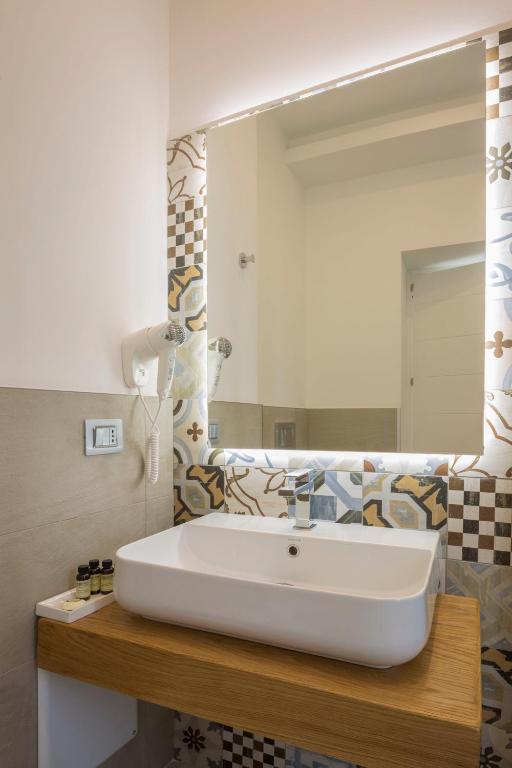 łazienka z białą umywalką i lustrem w obiekcie Townhouse Tropea w Tropei