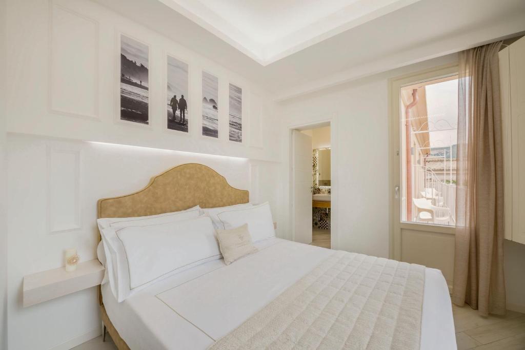 biała sypialnia z dużym łóżkiem i oknem w obiekcie Townhouse Tropea w Tropei