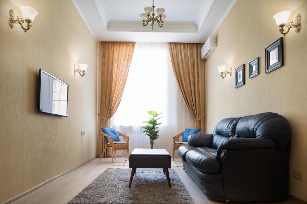 モスクワにあるMosAPTS apartments on Burdenkoのリビングルーム(黒い革張りのソファ、窓付)