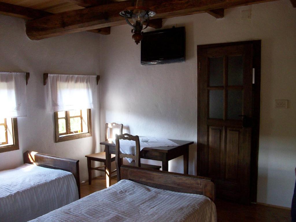- une chambre avec 2 lits, une table et une télévision dans l'établissement Ethno Village Stara Lonja, à Lonja
