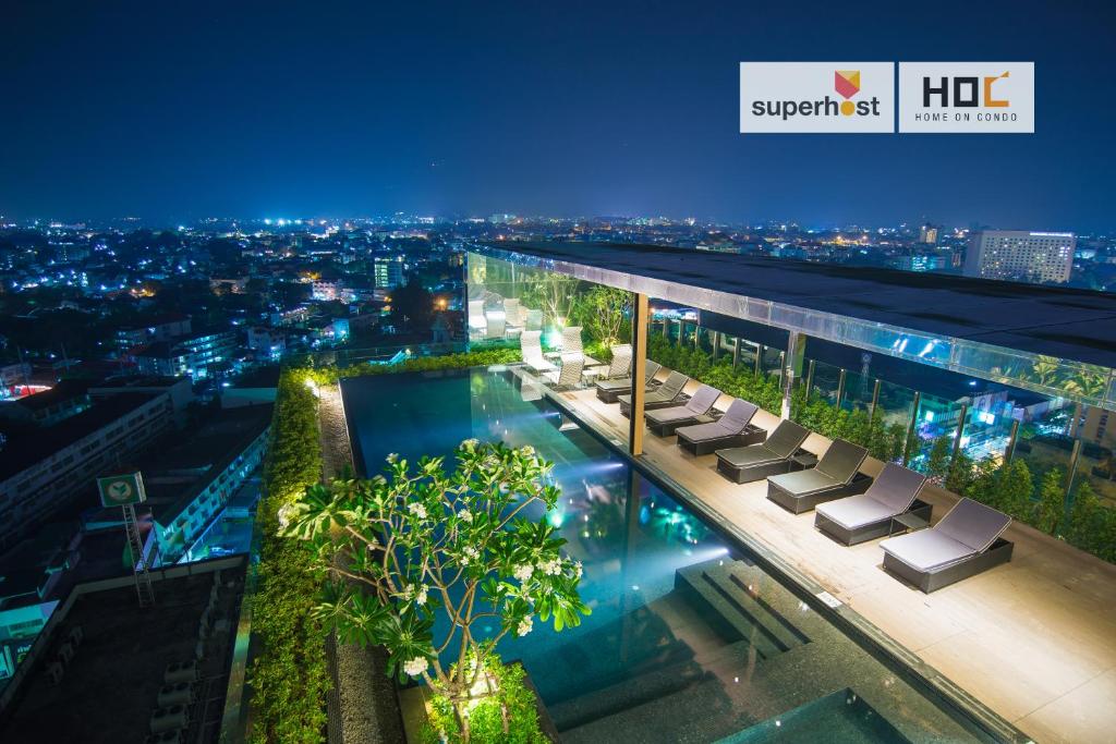 a view of a building with a swimming pool at night at The Astra Condo by Ping in Chiang Mai