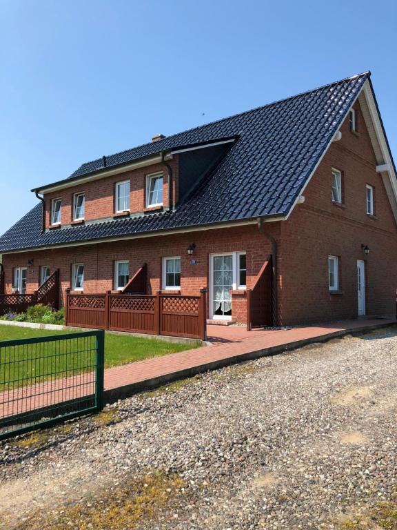 a red brick house with a black roof at Redewischer Str.23e in Boltenhagen