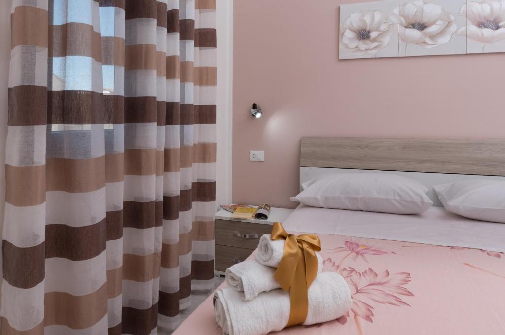 a bedroom with a bed with a blanket and a curtain at Tra la montagna e il mare in San Vito lo Capo