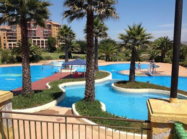 uma piscina com palmeiras num resort em Condominio ILIMAY em Las Cruces