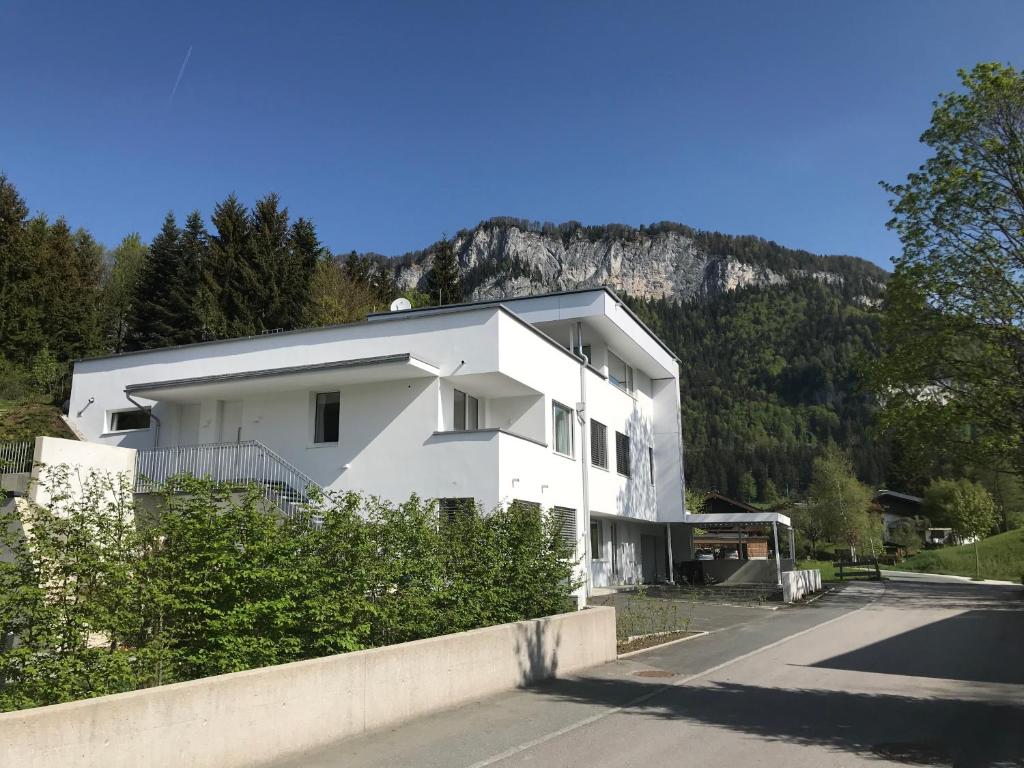 ein weißes Haus mit einem Berg im Hintergrund in der Unterkunft quartier39 in Sankt Johann in Tirol