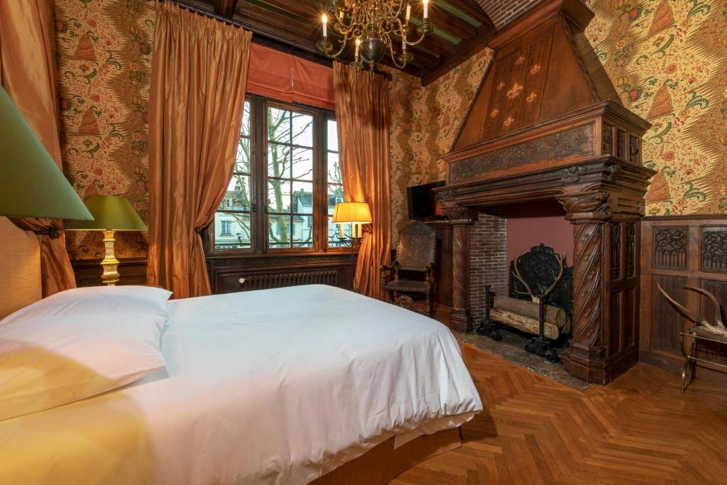 a bedroom with a large bed and a fireplace at La Maison Des Vieux Logis in Rouen