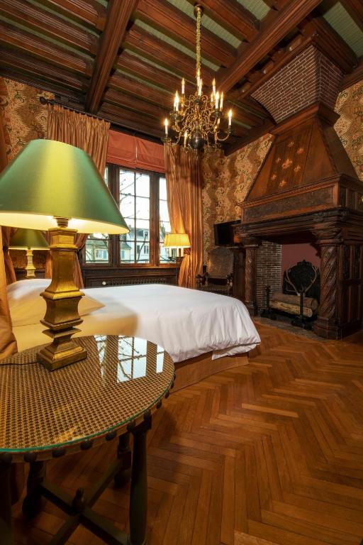 a bedroom with a bed and a table with a lamp at La Maison Des Vieux Logis in Rouen