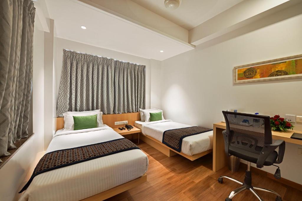 A bed or beds in a room at Hotel Leafio Marigold-Near Airport