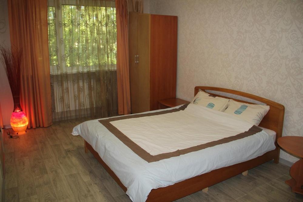 un dormitorio con una cama y una ventana en Современная 1-комнатная квартира, en Járkov