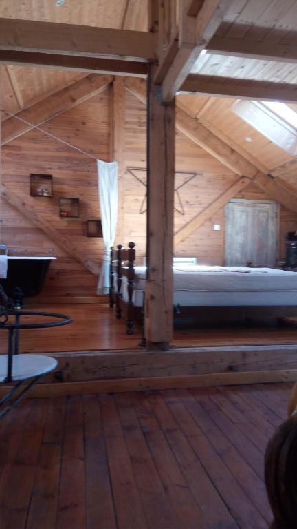 Cette chambre en bois comprend un lit dans un bâtiment en bois. dans l'établissement Au cœur de saint Agrève -Séjour Chez l'habitant, à Saint-Agrève