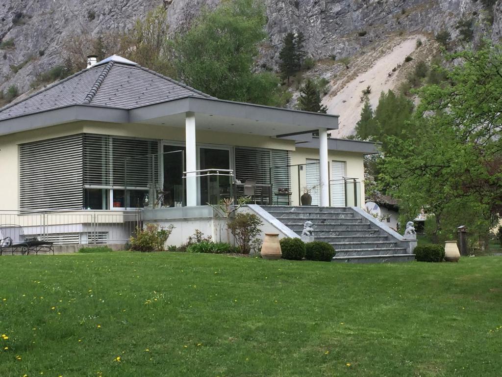a house with stairs and a grass yard at Chalet am See in Nassereith