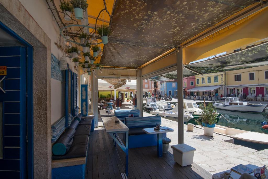 a restaurant with a patio with boats in the water at Bed&Breakfast Saturn in Veli Lošinj