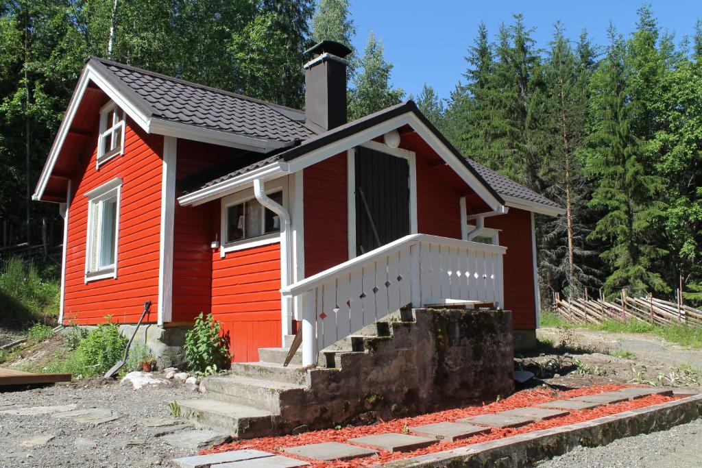a small red house with a staircase in front at Metsäpirtti in Kolinkylä