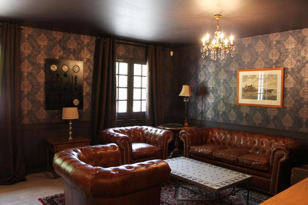 Elle comprend un salon doté d'un mobilier en cuir et d'un lustre. dans l'établissement Le Lodge des Bruyères, à Mont-Notre-Dame