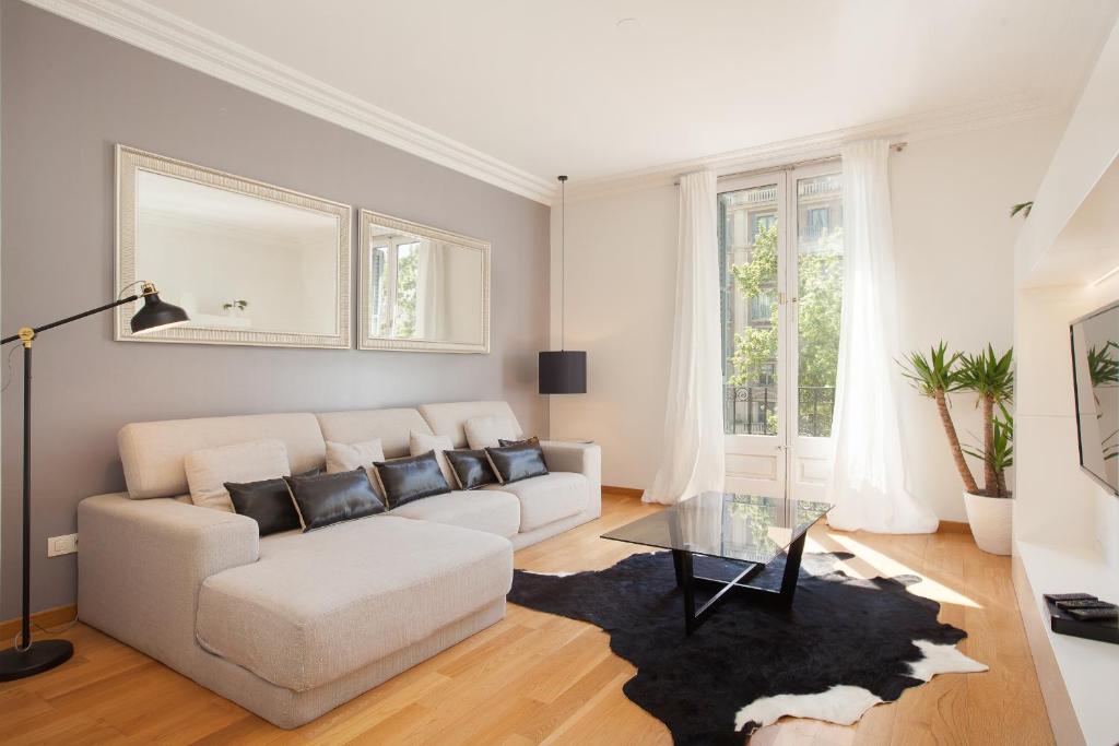 een woonkamer met een witte bank en een glazen tafel bij Rent Top Apartments Avenida Diagonal in Barcelona