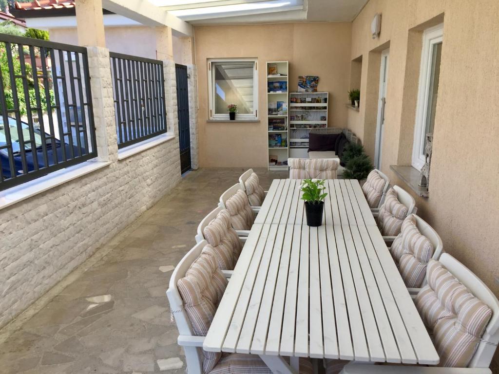 d'une grande table et de chaises blanches sur un balcon. dans l'établissement Apartments Marjana, à Portorož