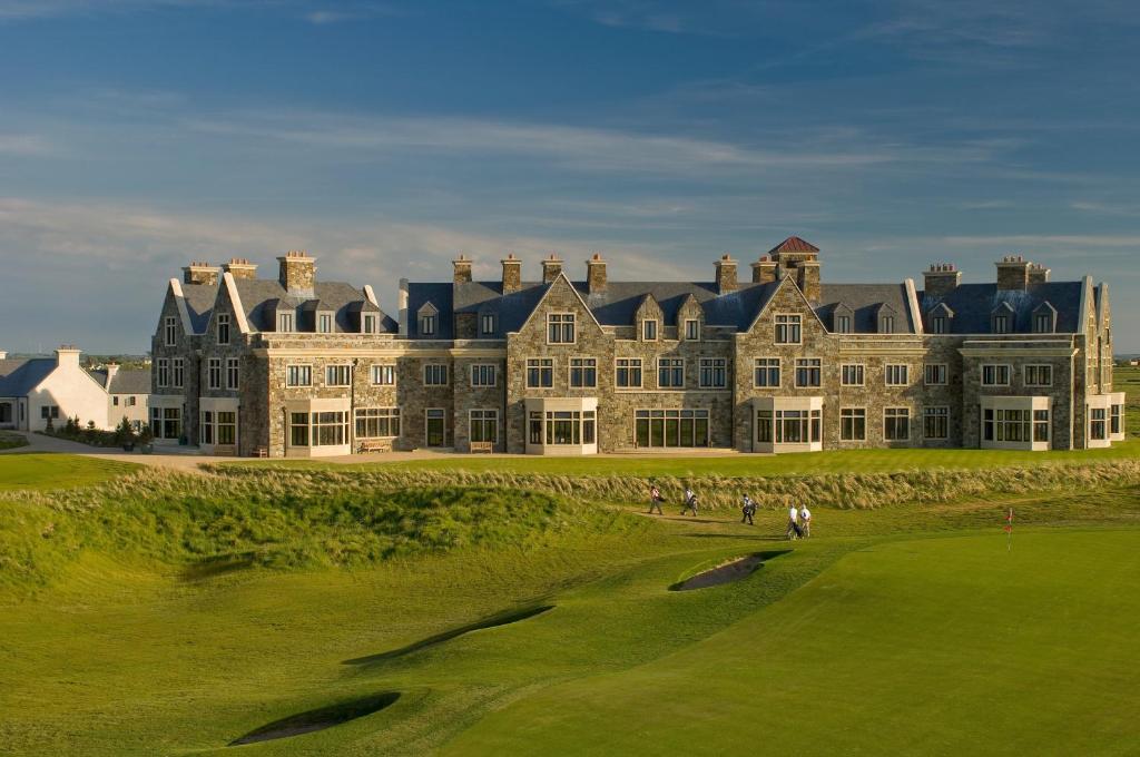ein großes Gebäude mit Leuten auf einem Golfplatz in der Unterkunft Trump International Golf Links & Hotel Doonbeg Ireland in Doonbeg