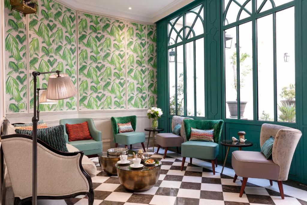 a lobby with green and white furniture and windows at Serotel Lutèce in Paris